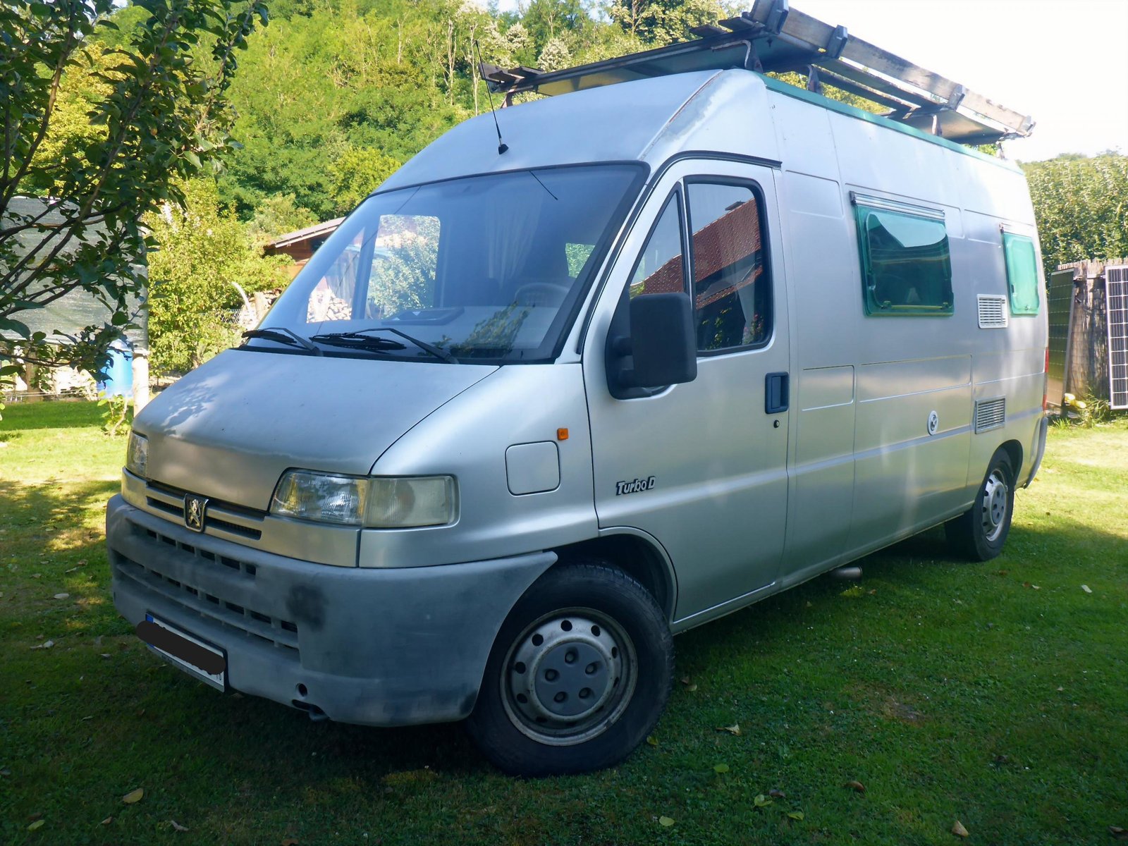 Pössl Wohnmobil auf Peugeot Boxer, Frontansicht mit Ausstellfenstern und Dachträger